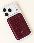 Cherry red Croc Leather Magnetic Phone Wallet attached to back of white iPhone