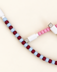 Close-up of burgundy and light blue beaded cable with white USB-C connector beside a pink beaded cable