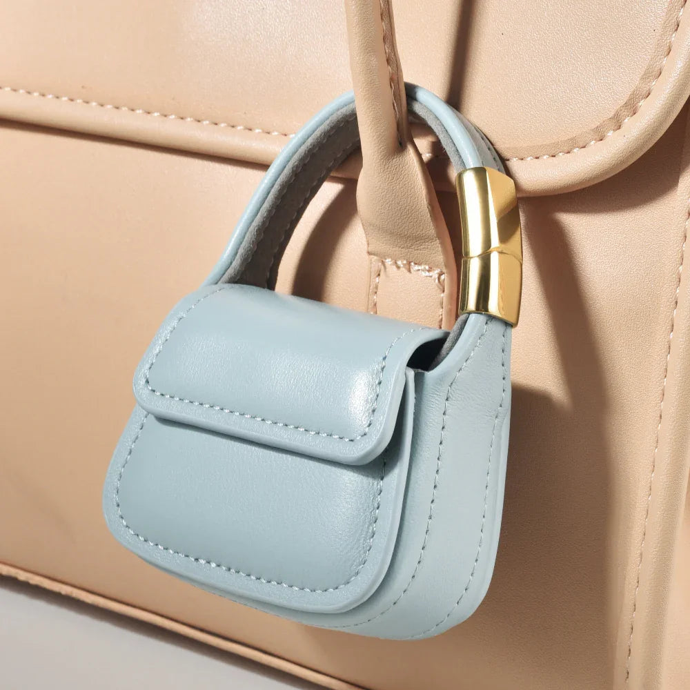 Blue leather mini purse charm attached to tote bag handle