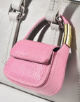 Pink leather mini purse charm attached to tote bag handle