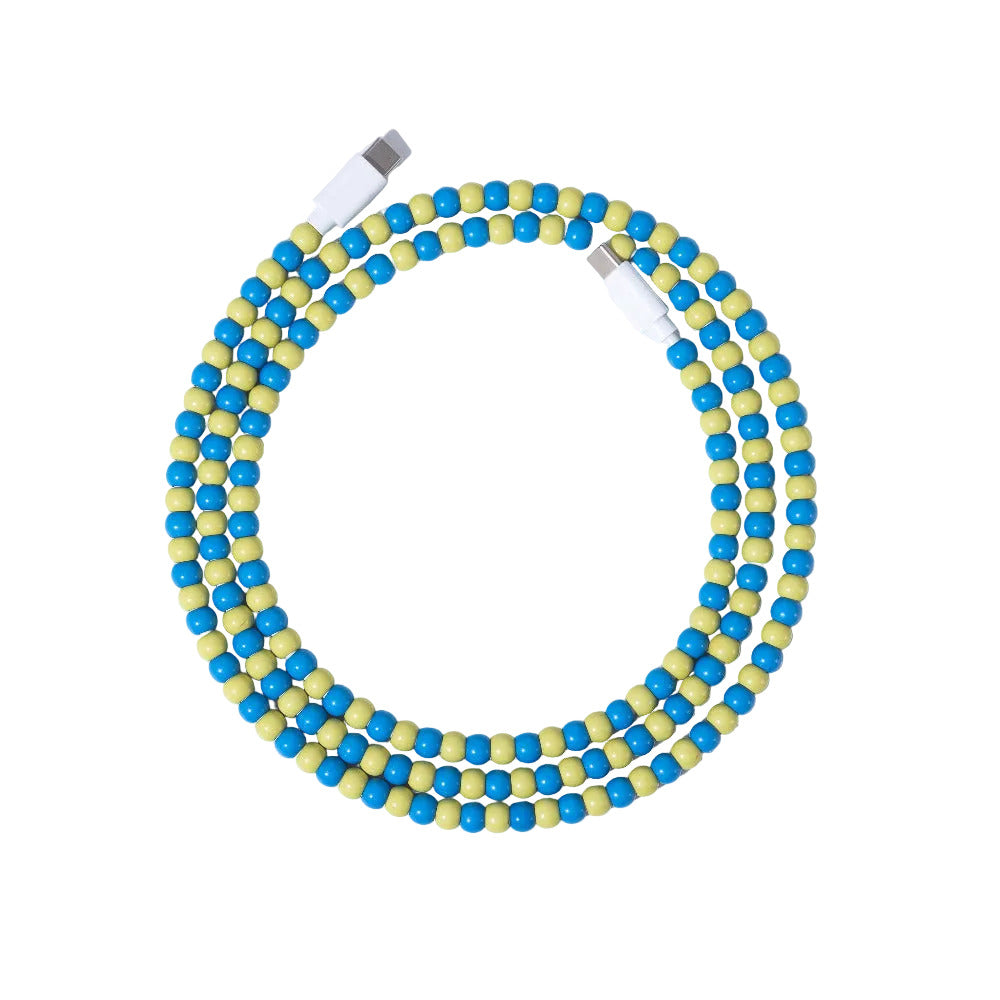 Blue and yellow USB-C beaded charging cable coiled on lavender background